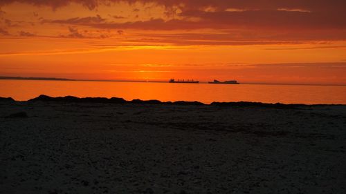 Scenic view of sea against orange sky