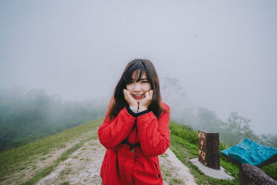 Portrait of smiling young woman standing during winter