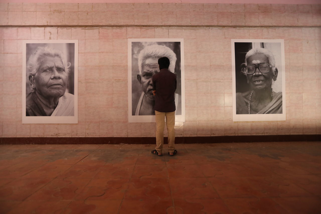 REAR VIEW OF WOMAN STANDING AT MUSEUM