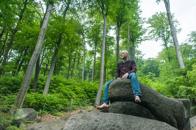 Full length of woman standing on tree trunk