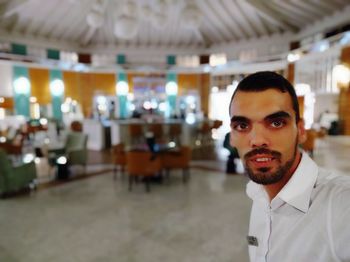 Portrait of young man standing in restaurant