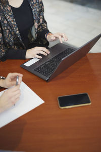 Mid section of woman using laptop