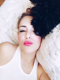 Portrait of beautiful woman lying on bed