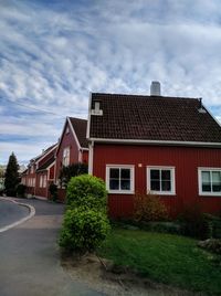  red houses by road against sky