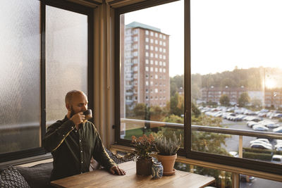 Man sitting on table by window