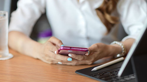 Midsection of woman using mobile phone