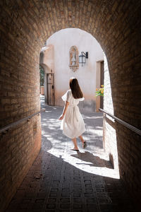 Rear view of a woman walking in archway