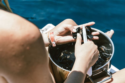 Midsection of man holding umbrella at sea shore