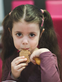 Portrait of a beautiful one child girl eating ice cream in a cafe.