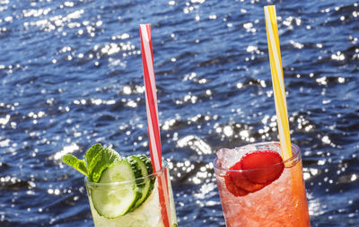 Close-up of drinking glass with alcoholic drink  in sea