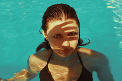 Portrait of young woman swimming in pool