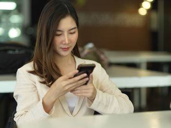 Young businesswoman using mobile phone at office