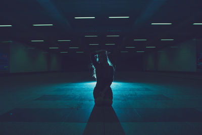 Young woman kneeling in underground walkway