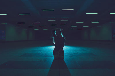 Young woman kneeling in underground walkway