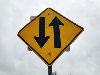 Low angle view of road sign against sky