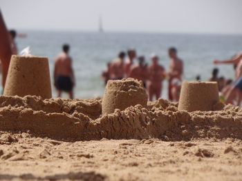 Rear view of couple on beach against sky