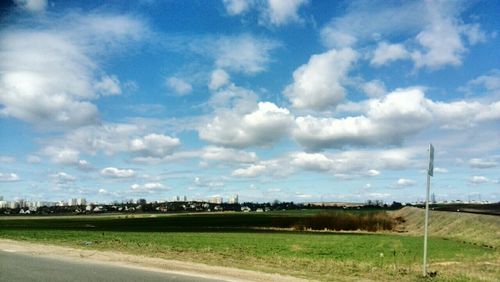 View of field against cloudy sky