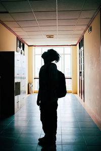 Rear view of silhouette woman standing in corridor of building