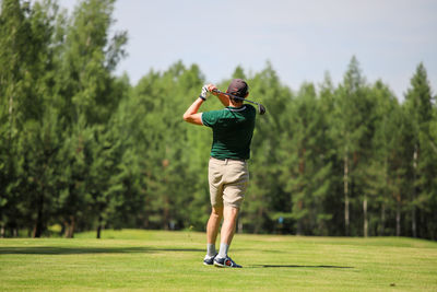 Rear view of man standing on golf course