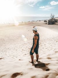 Full length of woman standing on beach against sky