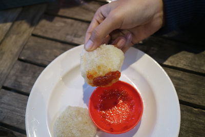 Hand holding fried cireng with chili sauce photo