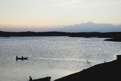 Silhouette of boats in sea at sunset