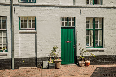 Facade of brick house with door and windows in a small alley at bruges. belgium.