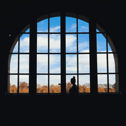 Silhouette people looking through window