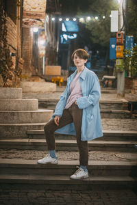 Portrait of man standing on staircase in city