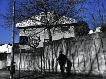 Rear view of man walking by building