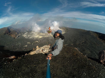 Man climbing on mountain against sky