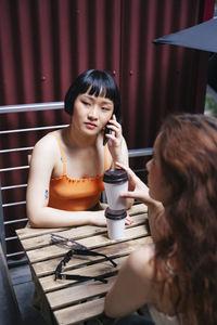 Portrait of young woman sitting on table