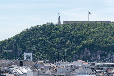 Buildings by sea against sky