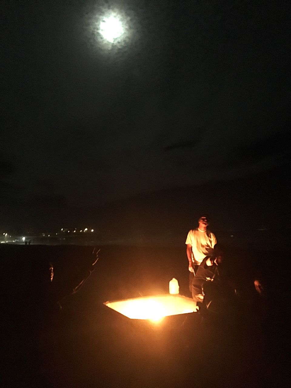 lifestyles, leisure activity, standing, night, illuminated, men, burning, flame, fire - natural phenomenon, sun, full length, casual clothing, glowing, rear view, young adult, person, holding, sitting