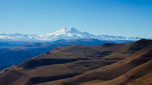 Scenic view of snowcapped mountains against clear blue sky