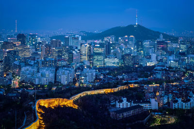 High angle view of illuminated city buildings against sky