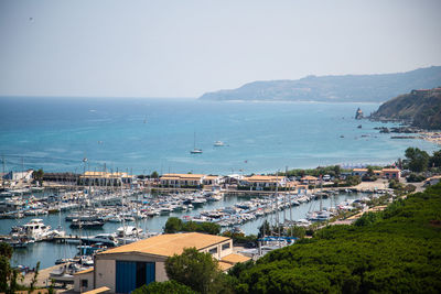 High angle view of townscape by sea against sky