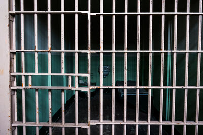 Close-up of metal grate in cage at building