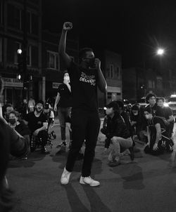 People standing on street in city at night