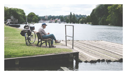 Rear view of man sitting on pier