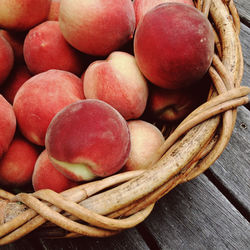 High angle view of peaches in wicker basket on table