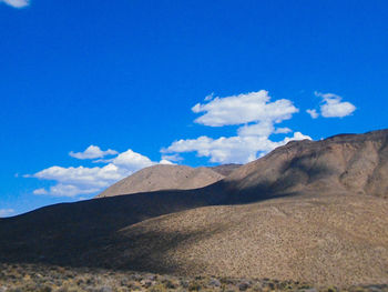 Scenic view of mountains against blue sky