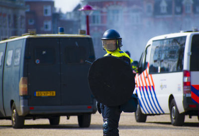 Rear view of man standing on street in city