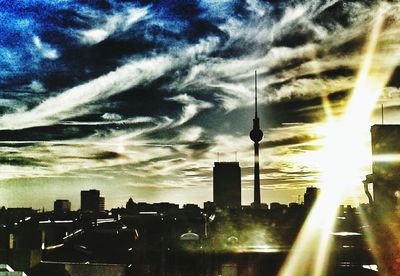 Cityscape against cloudy sky at sunset