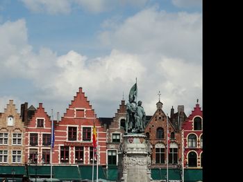 View of buildings in city against cloudy sky