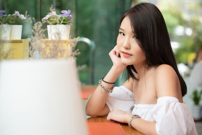 Portrait of a smiling young woman sitting outdoors