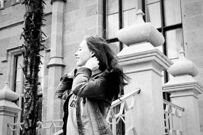 Low angle view of woman standing against historic building