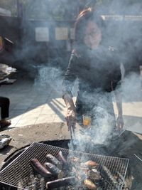 Woman preparing food on barbecue grill