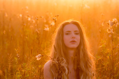 Portrait of beautiful young woman on field