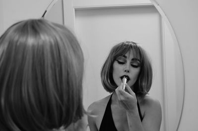 Close-up of young woman looking in the mirror